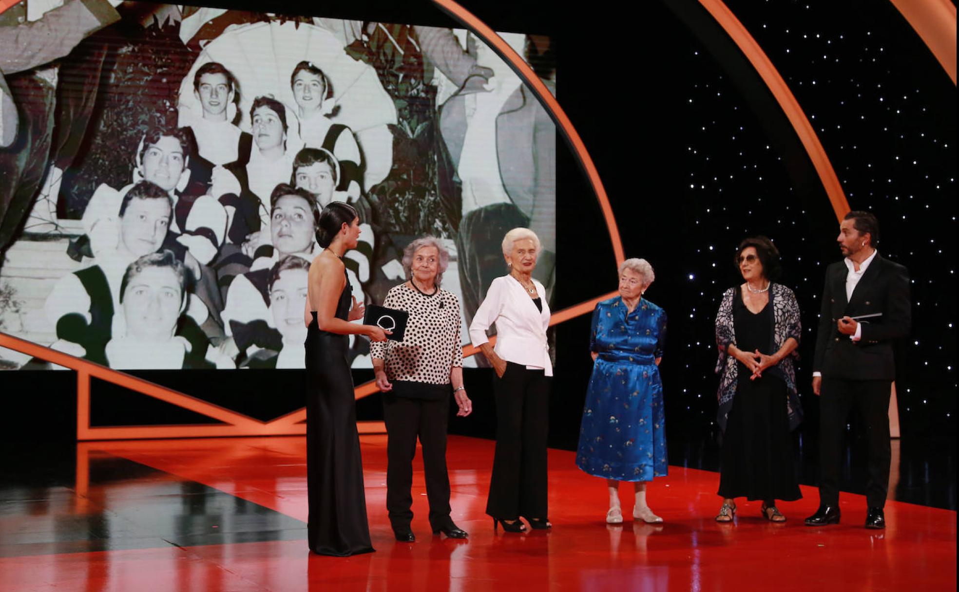 Cuatro dantzaris de las primeras ediciones del Festival en el escenario junto a los presentadores de la gala