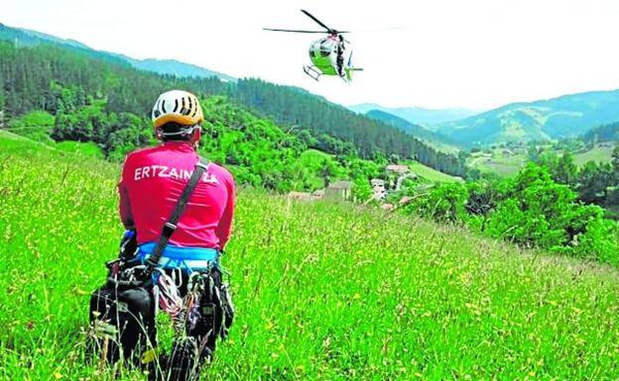 Uno de los agentes de la Unidad de Vigilancia y Rescate de la Ertzaintza observa un helicóptero de la brigada. 