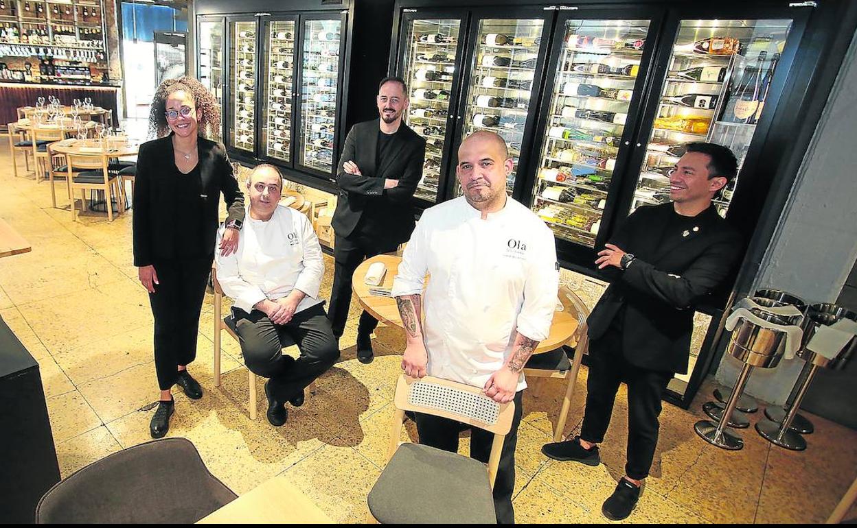 El equipo de La Bodega de Ola posa entre su amplia y preciosa selección de botellas. 