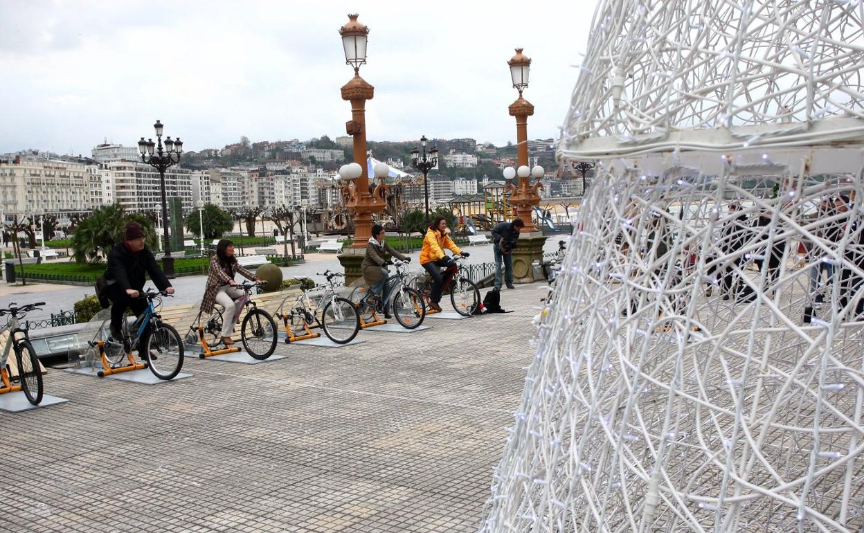 Varias personas pedalean en las bicicletas instaladas en la terraza del Ayuntamiento en 2008 para el encendido del árbol de Navidad. 