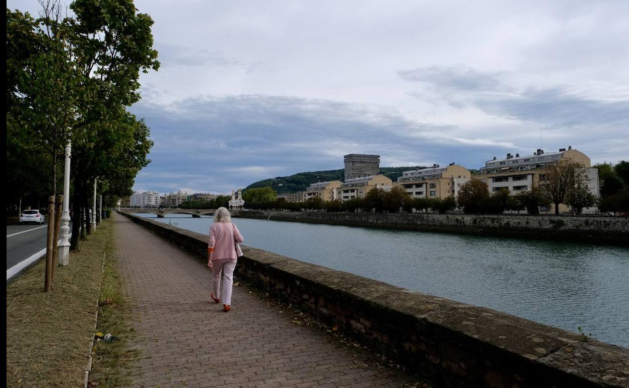 Una mujer pasea con chaqueta por Donostia.