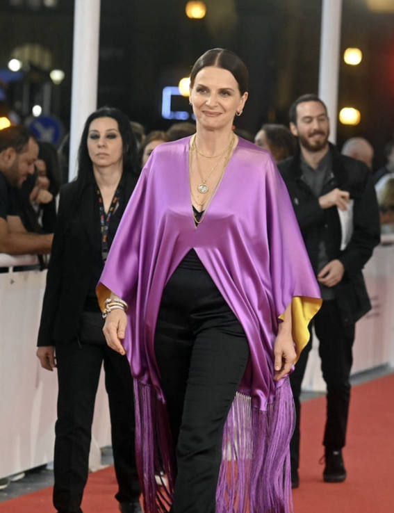 Lo más destacado del look: la capa "torera" asimétrica con flecos en lila y amarillo lucida por Juliette Binoche. Sólo ella se puede permitir lucir una pieza de este corte con tanta elegancia sobre una alfombra roja