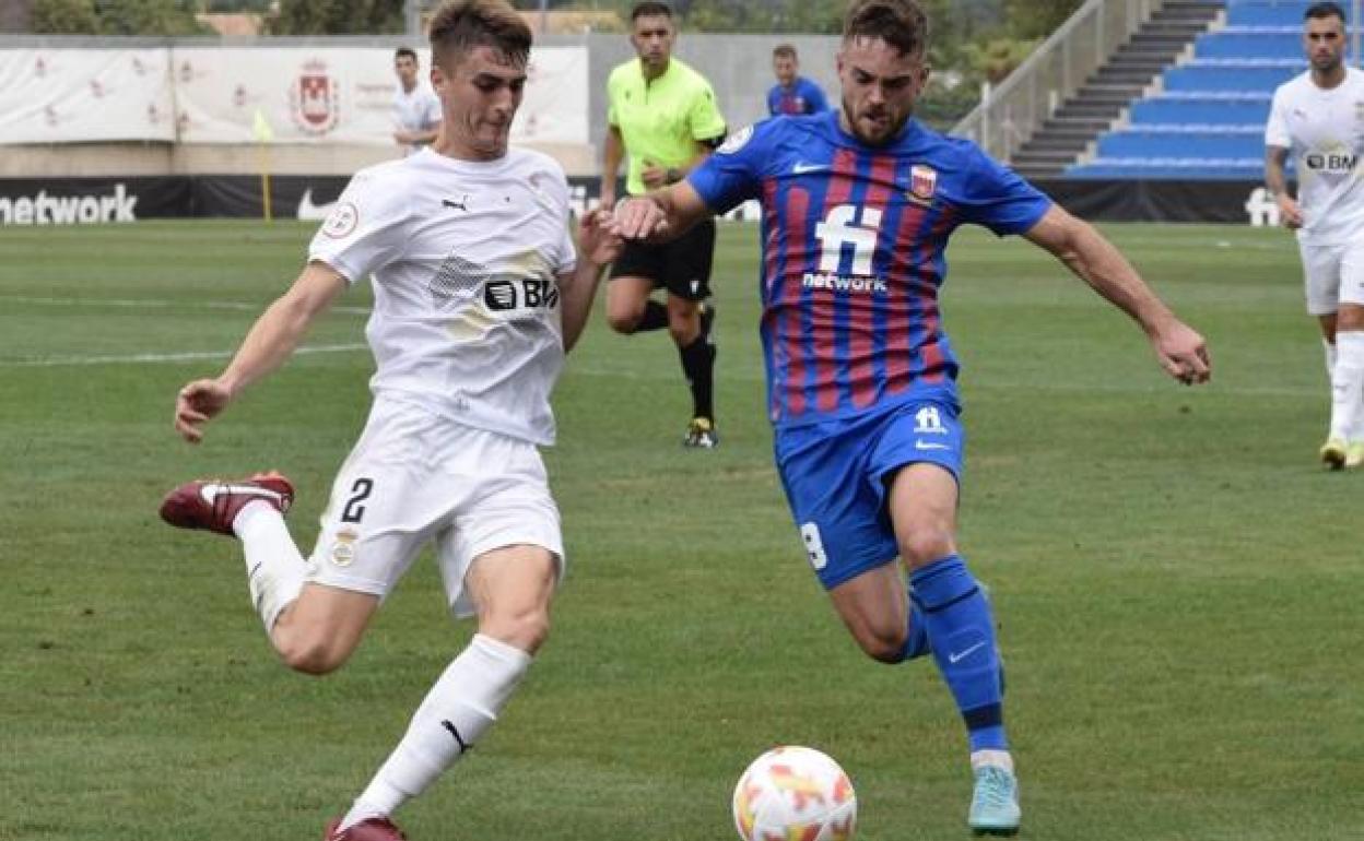 Jaso disputa un balón con Soberón en el partido disputado en Elda. 