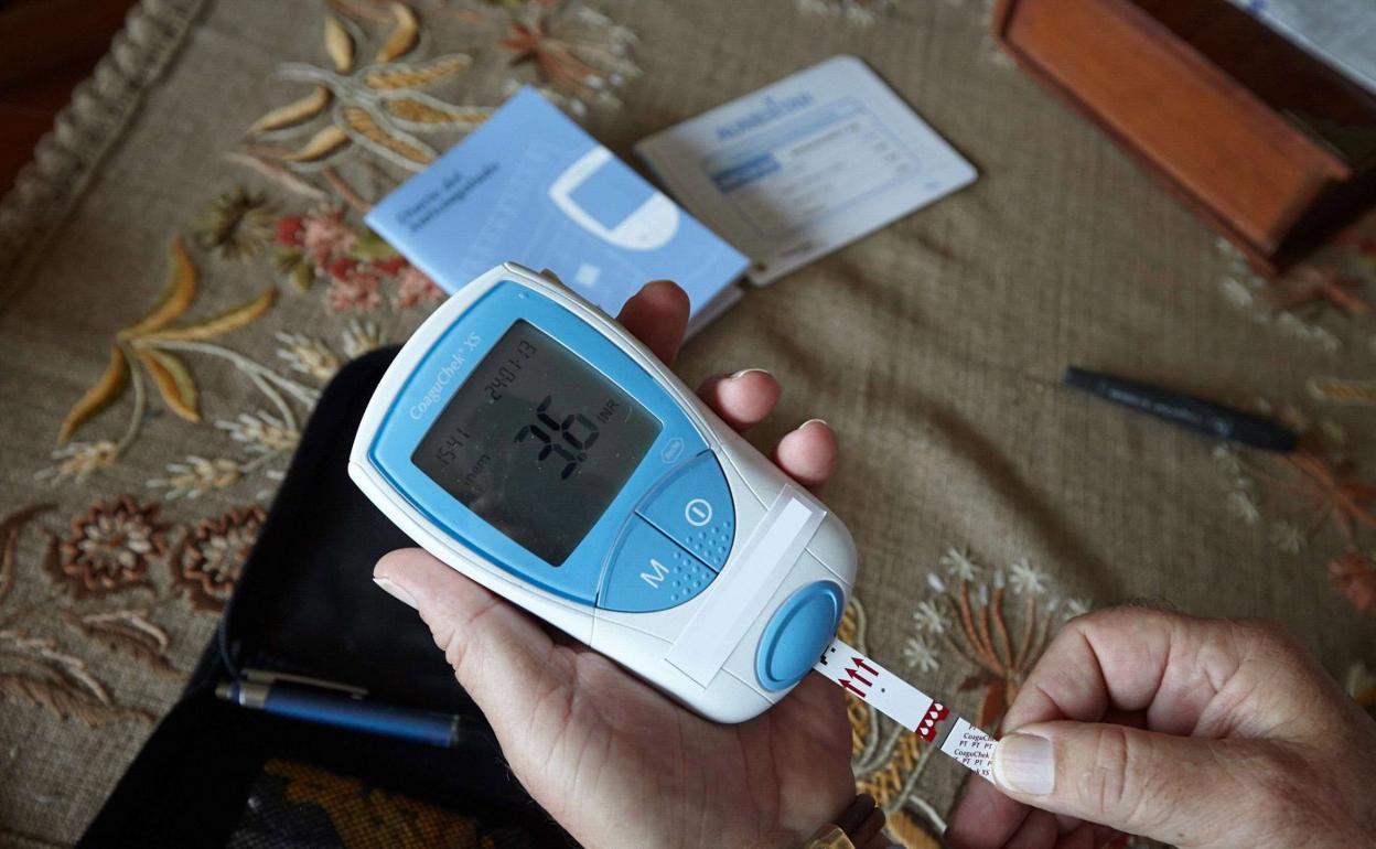 Un paciente mide el nivel de coagulación de su sangre en su domicilio de Donostia. 