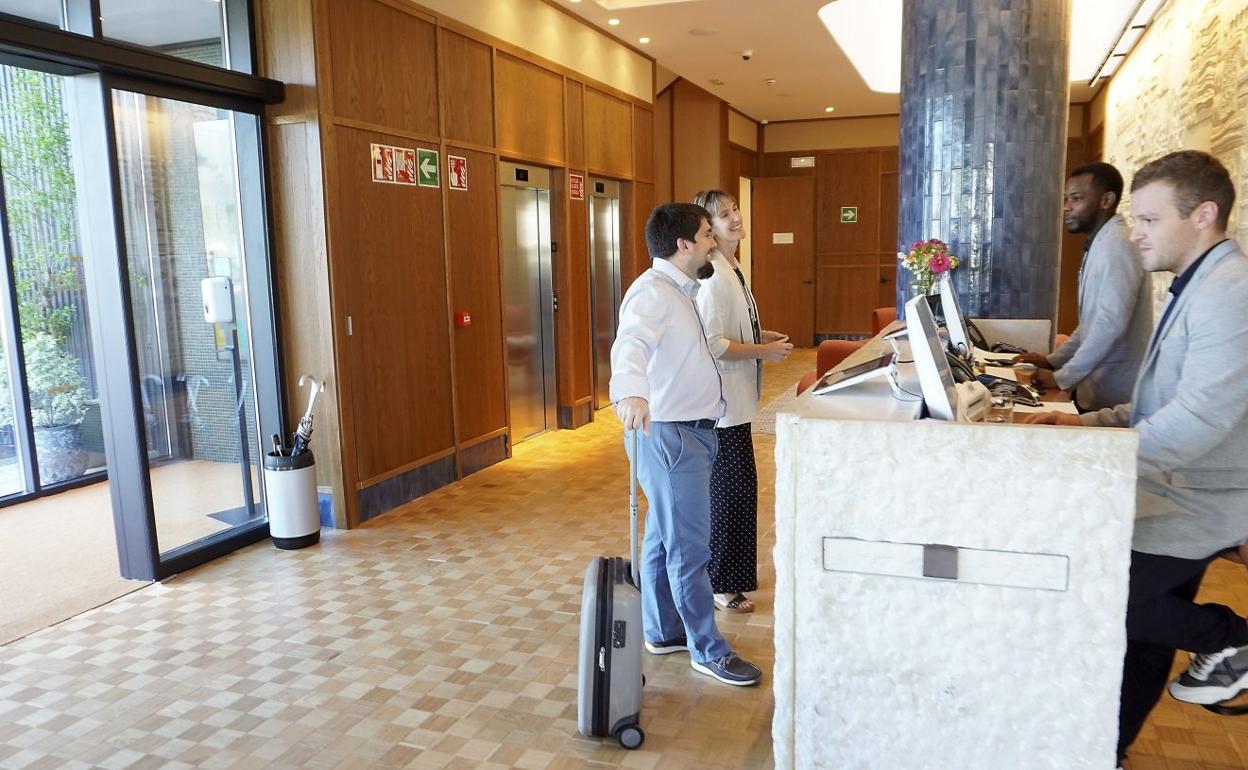 Dos clientes se registran en la recepción de un hotel donostiarra. 