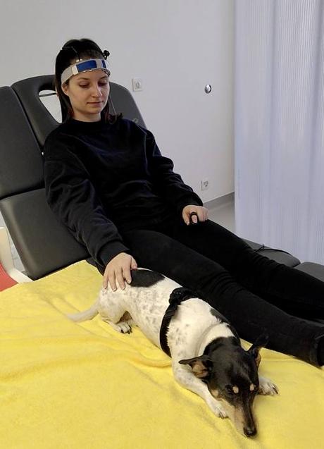 Imagen - Una participante en el estudio mientras le miden la actividad cerebral acariciando a un perro. /Marti et al., CC-BY 4.0