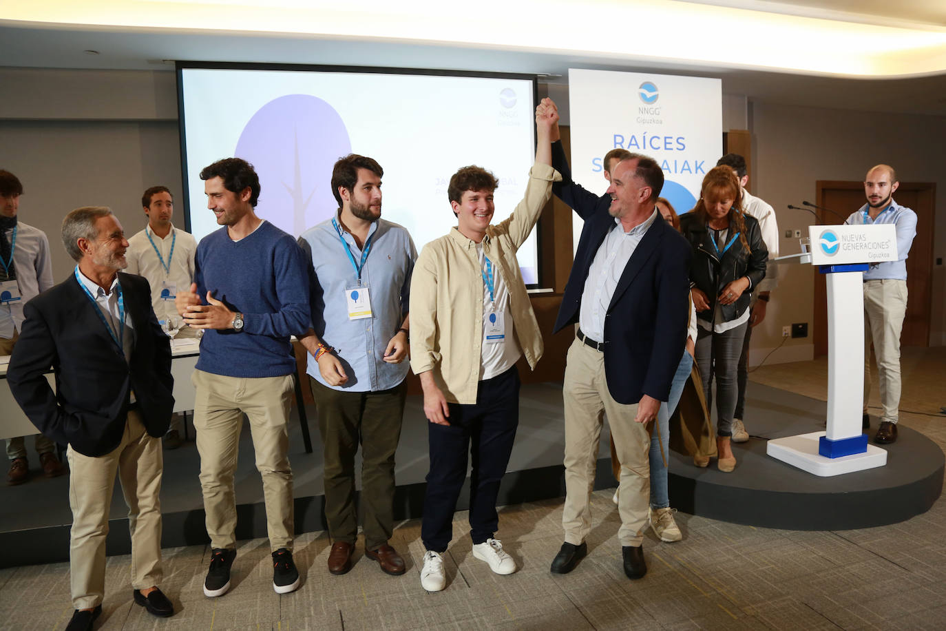 Carlos Iturgaiz levanta la mano de Adrián Ortúñez, nuevo presidente de Nuevas Generaciones de Gipiuzkoa.