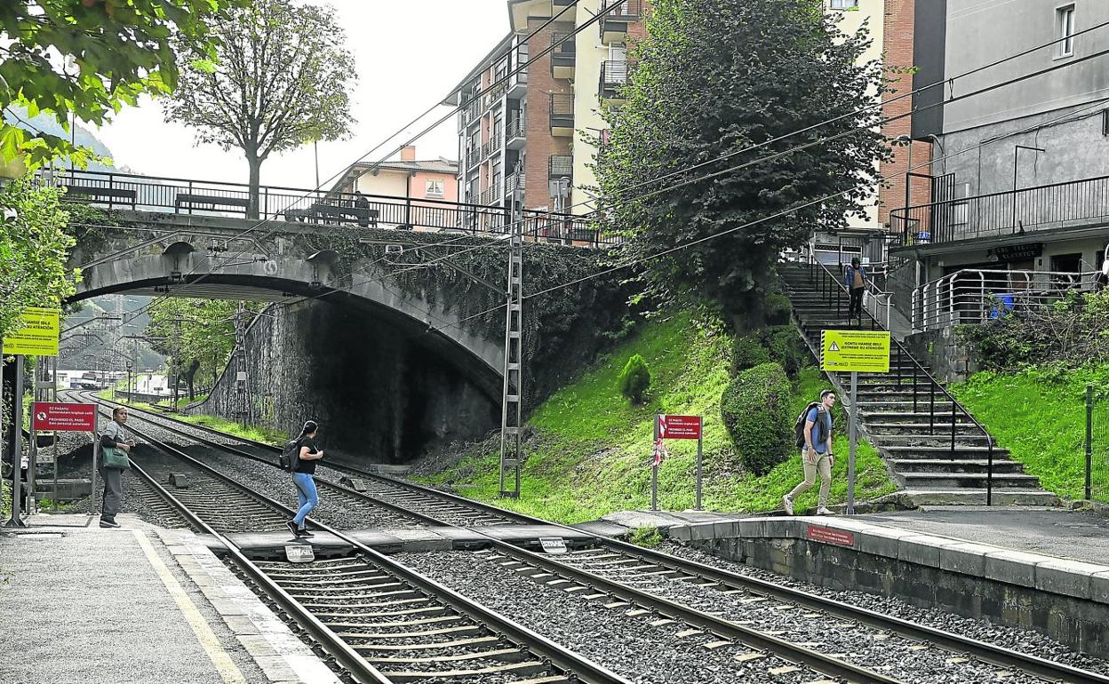 Una chica va de un andén a otro por donde murió Salah, en la otra vía que viene de Tolosa. Los carteles rojos prohíben continuar andando por debajo del puente. Los amarillos sugieren «mirar a ambos lados antes de cruzar». 