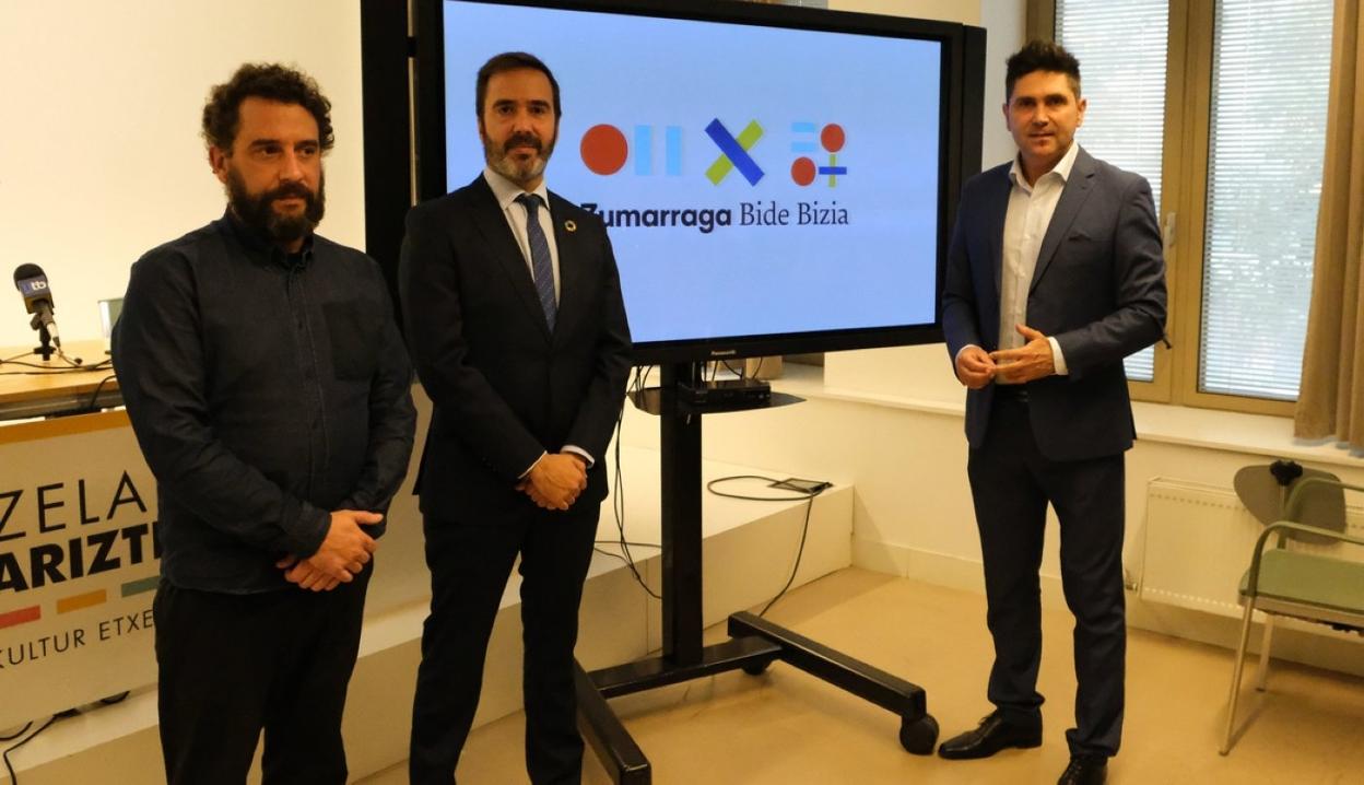 Iñigo del Canto, de Vera estudio, el consejero Javier Hurtado y el alcalde Mikel Serrano con el logotipo. 