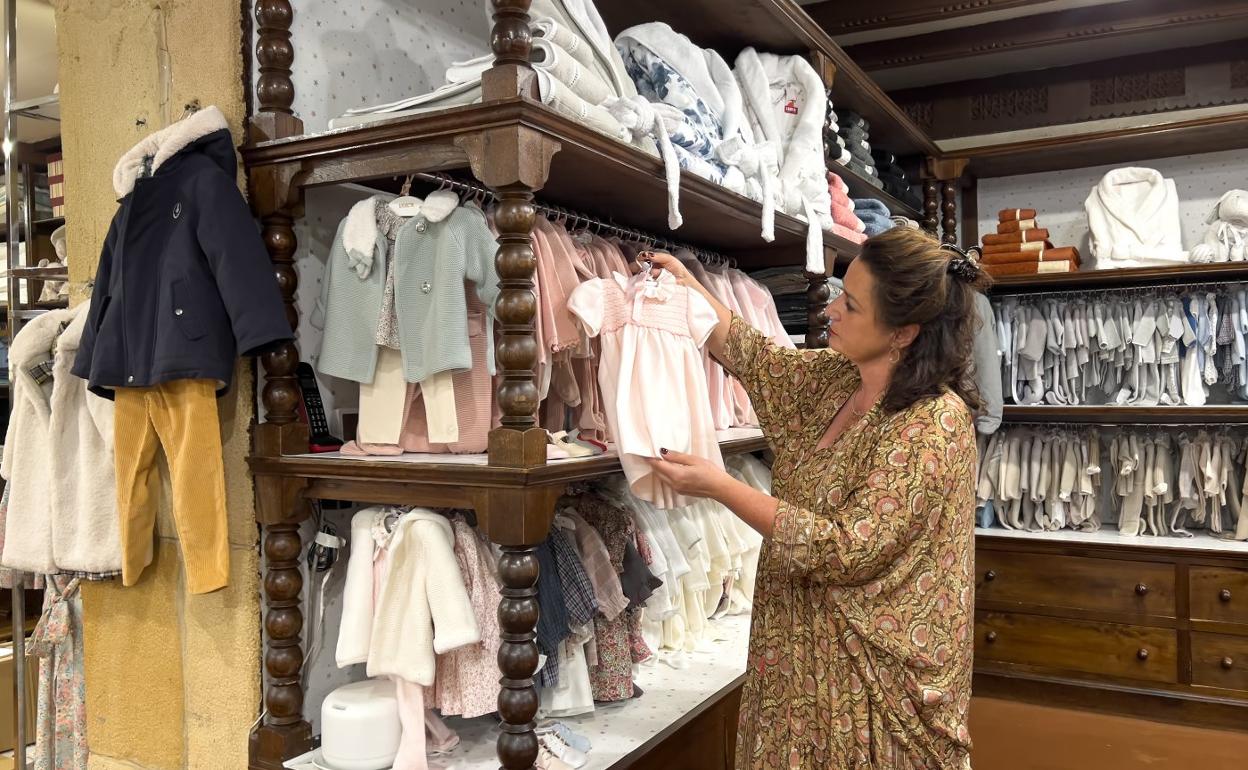 Ayago Villar enseña un traje de bebé en la tienda Irulea. 