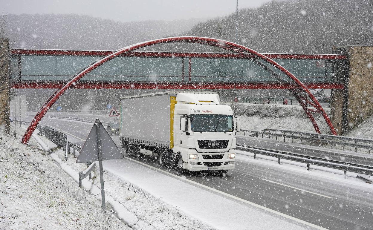 Un camión avanza por la A-15, en Pagozelai, rodeado por la nieve.