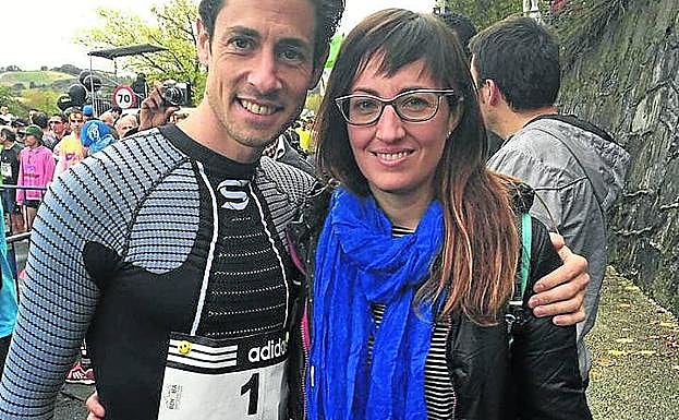 Imagen principal - Arriba, Pedro Nimo en la Behobia de 2014, con la hermana de Arantza, fallecida en 2013. Abajo a la izquierda, cartulina de apoyo de unas jóvenes, trofeo, txapela y ramo de 2013. A la derecha, Nimo sube destacado el alto de Miracruz en 2013, cuando ganó.
