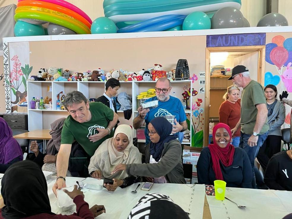 Reparto. Voluntarios ytrabajadores refugiadosentregan los menús amujeres y niños en n