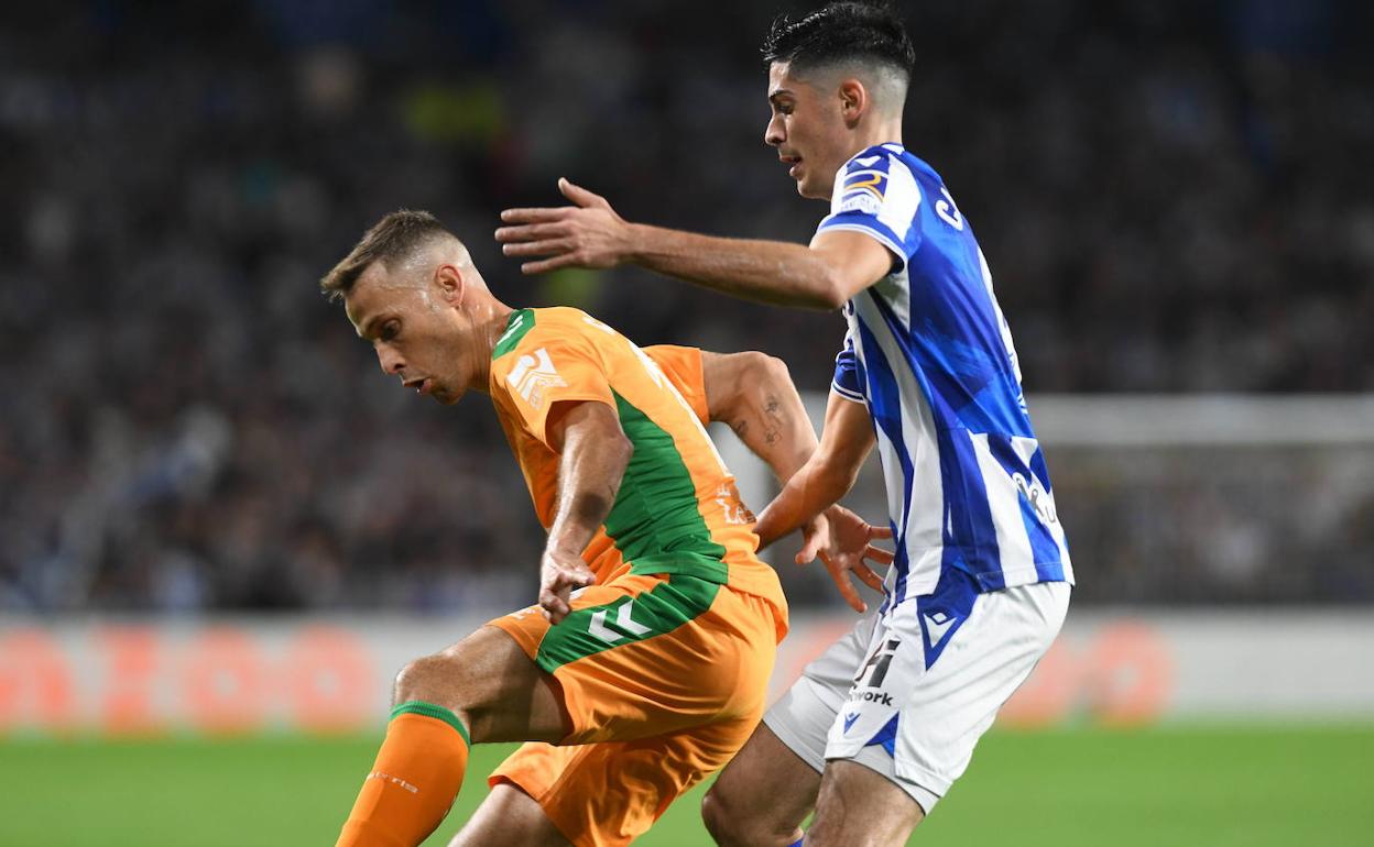 El exrealista Sergio Canales disputa el balón con Carlos Fernández en el partido en el Reale Arena.