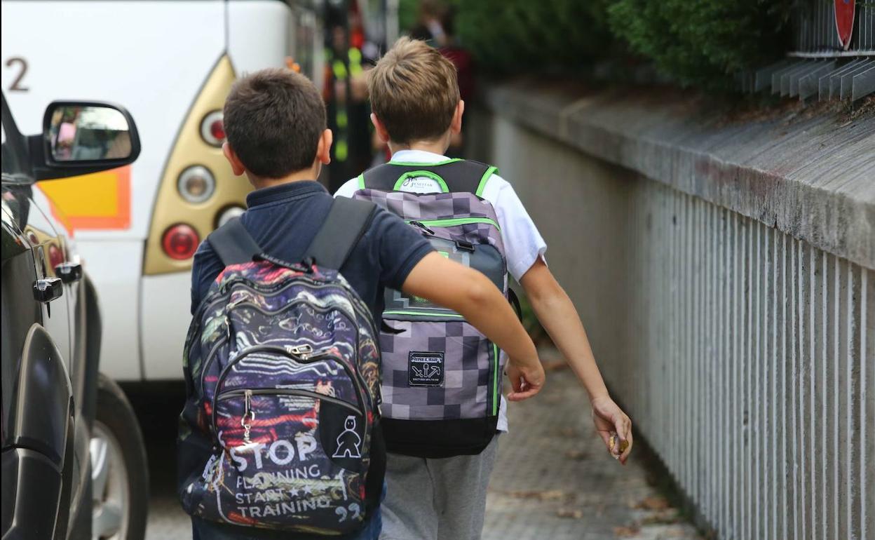 Dos niños se dirigen a clase. 