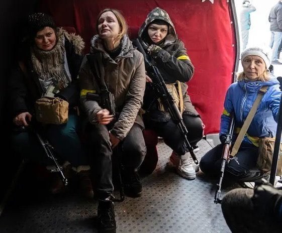 Cuatro mujeres esperan el momento de subirse a un transporte militar para ser trasladadas al frente en Ucrania