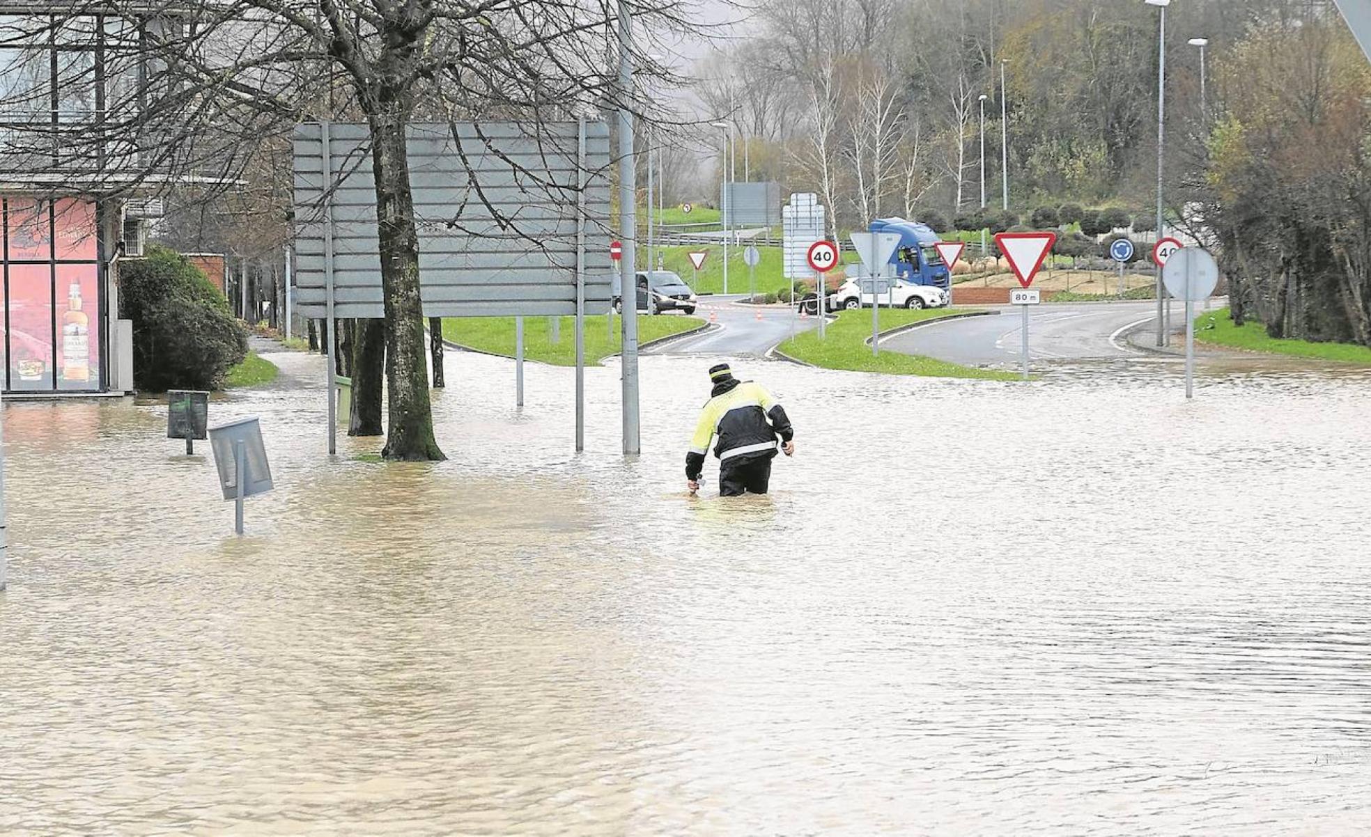 Un policía local de Irun camina en medio de la riada en la zona de Behobia el 10 de diciembre de 2021. 