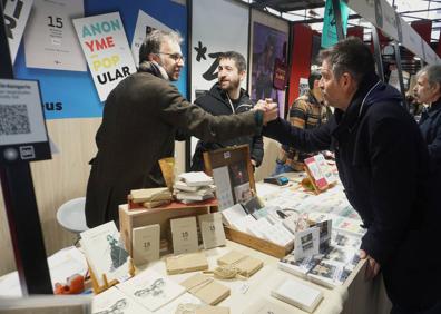 Imagen secundaria 1 - Asisko Urmeneta firma ejemplares de 'Amaiur! Libera State', una visión ilustrada y muy documentada de lo que ocurrió en Amaiur. Harkaitz Cano y Oier Aranzabal en el stand del colectivo Zart!, atendiendo a visitantes ilustres. El geógrafo y profesor japonés Ishii Hisao presentó ayer su tesis sobre Durangoko Azoka.
