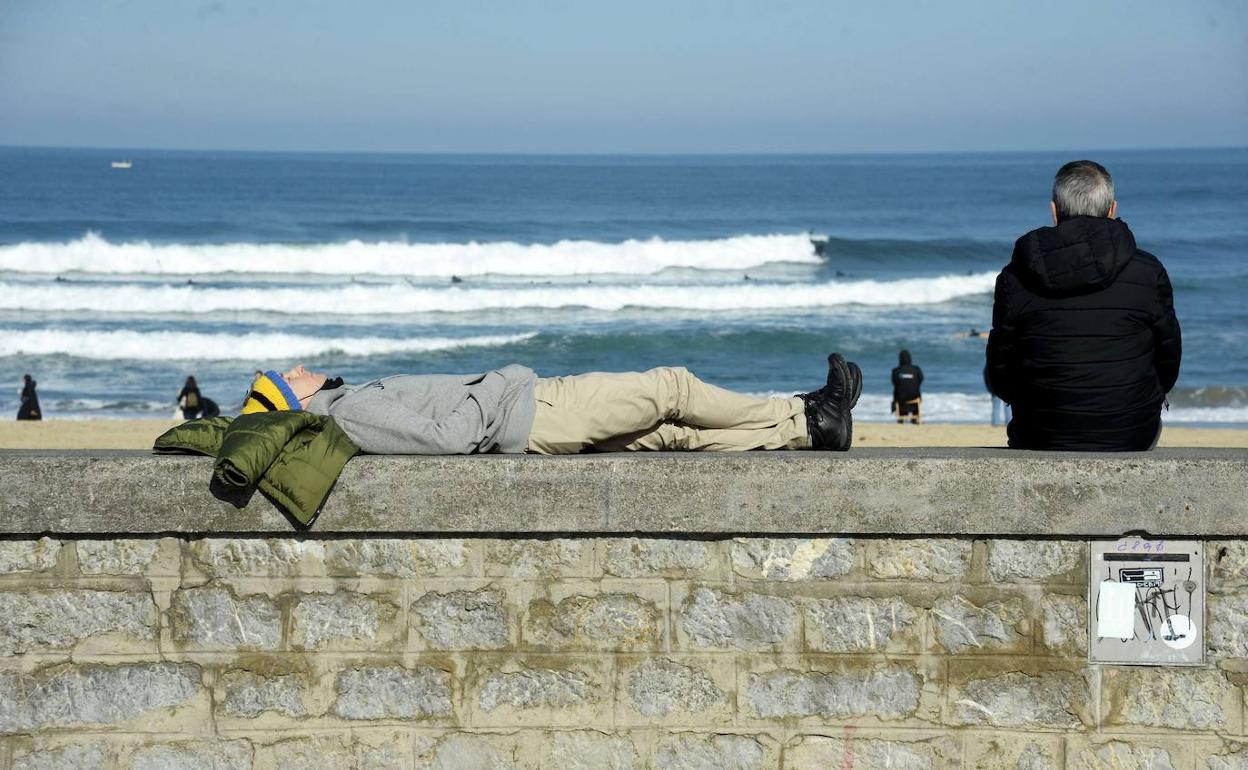 Varias personas descansan al sol en Donostia.