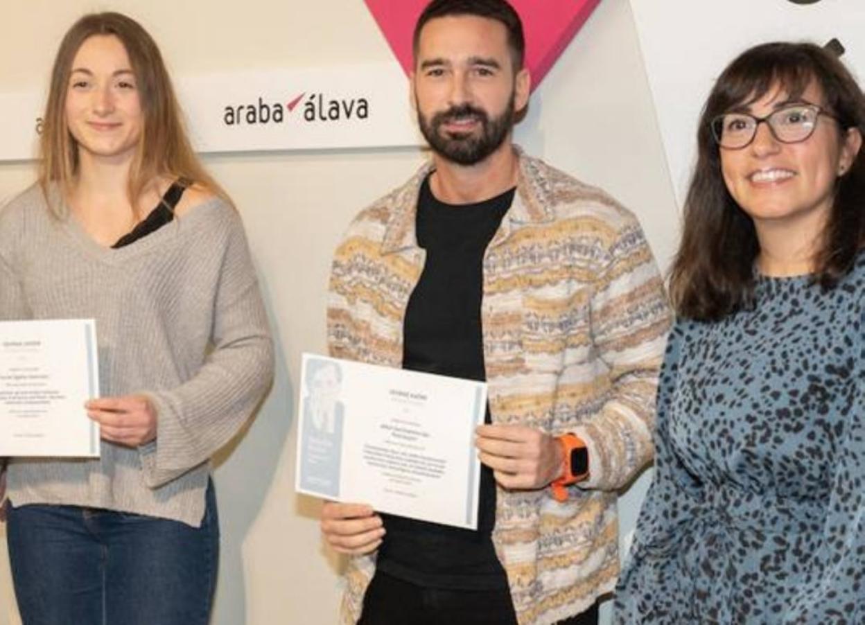 Anne Egaña y Mikel Gartziarena posan con sus becas junto a Lexuri Ugarte, directora foral de Euskera. 