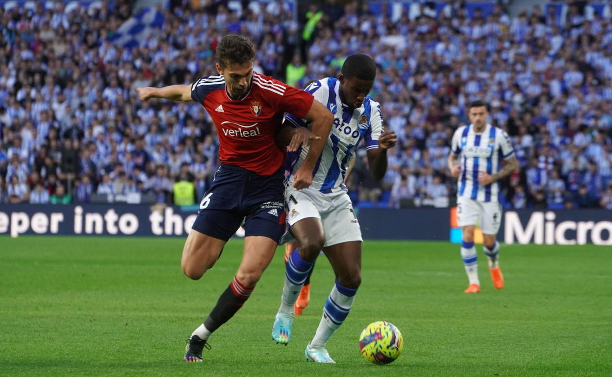 Cho forcejea con Torró para proteger la pelota.