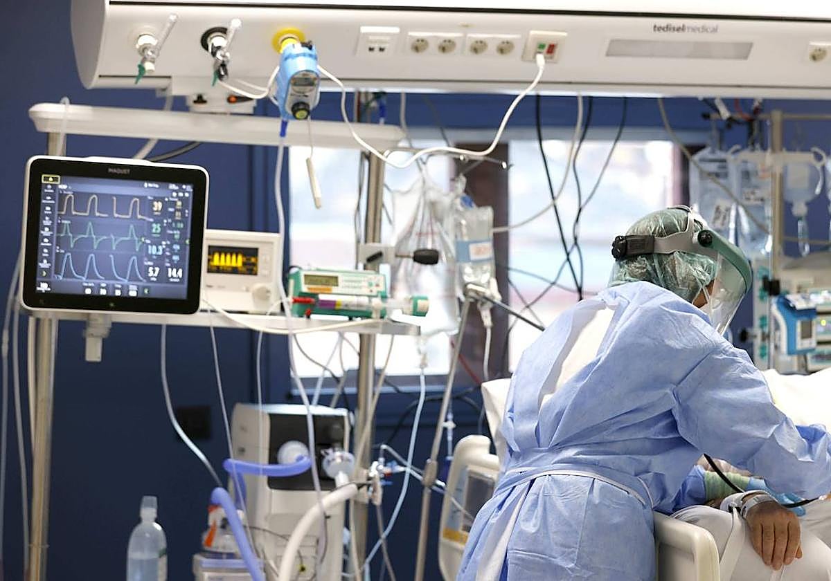 Una sanitaria atiende a un paciente con coronavirus en la UCI.