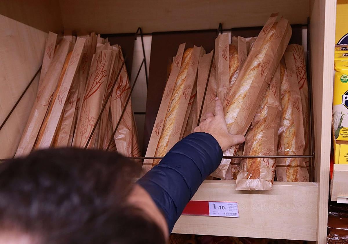 Un hombre compra pan en un supermercado.