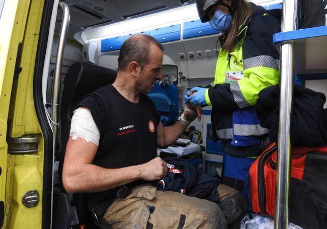 Los servicios de emergencia atienden al bombero herido en el incendio.