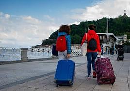 Dos turistas con maletas por Alderdi Eder.