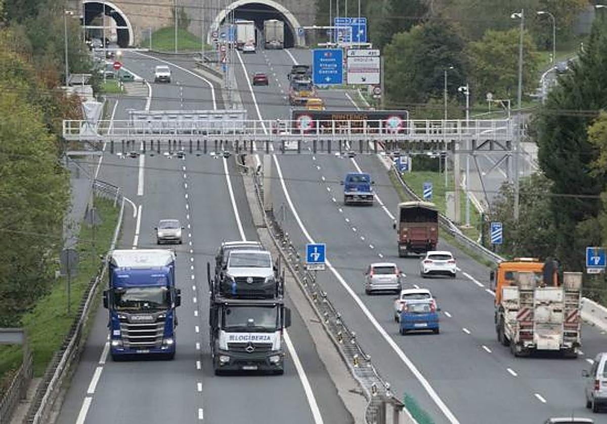 Camiones circulando bajo un arco para el cobro de peaje.