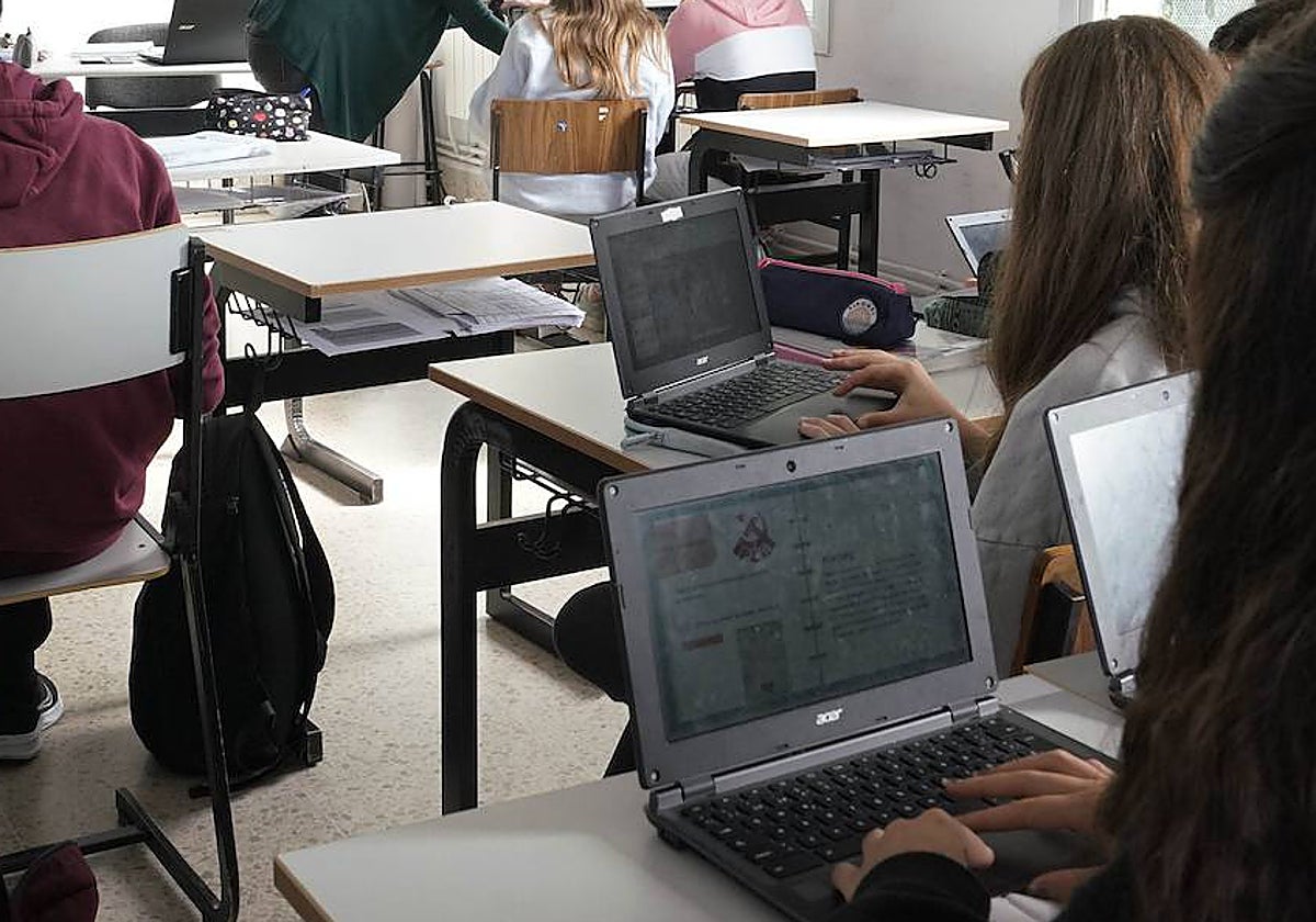 Un grupo de alumnos siguen sus clases con los ordenadores.