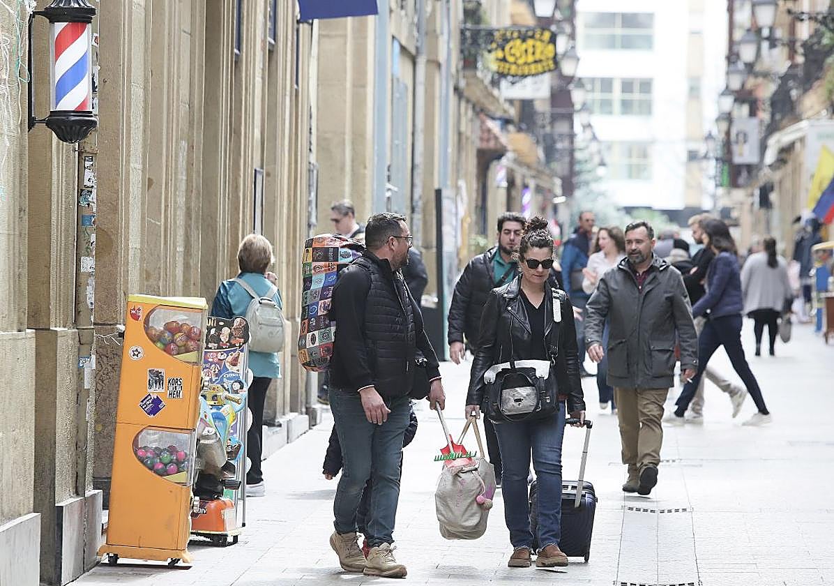 Turistas con maletas en la Parte Vieja de San Sebastián.