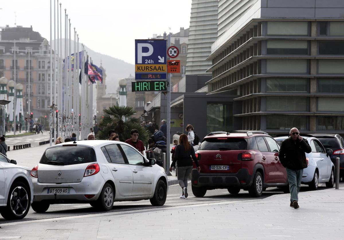 Varios vehículos con matrícula francesa espera para aparcar en un parking del Kursaal lleno.