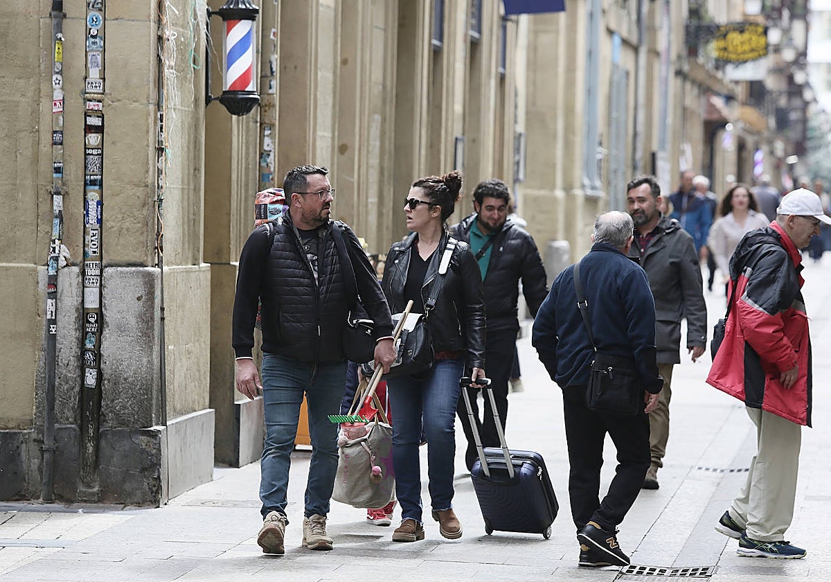 Dos turistas caminan por una calle de la Parte Vieja donostiarra.
