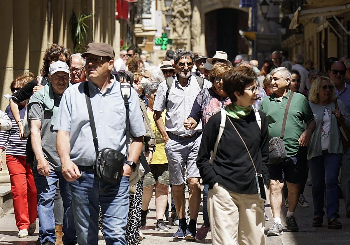 Un grupo de turistas recorre la calle Mayor, en la Parte Vieja donostiarra.