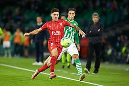 Montiel (de rojo) disputa un balón con Tello.