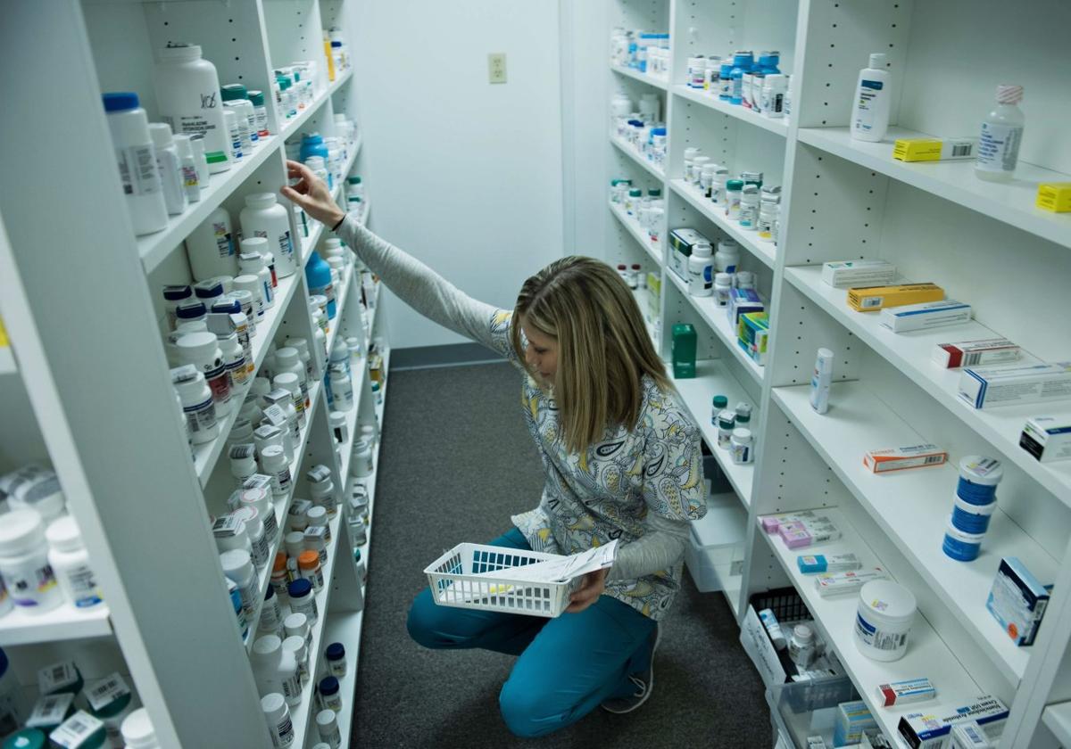 Una farmacéutica inspecciona el almacén de una botica, donde guarda los fármacos.