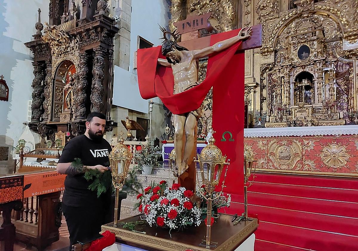Aitor Ugarte adornando este miércoles con flores el Cristo de Bonanza, uno de los pasos que abre la procesión del Santo Entierro.