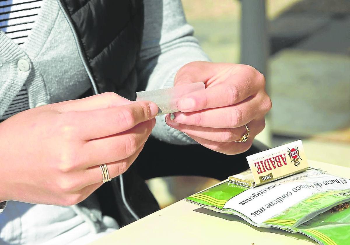 Una mujer lía un cigarro en una terraza en San Sebastián.