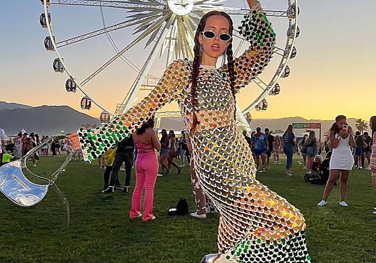 Marta Sierra con vestido de brillos posando delante de la noria del festival.