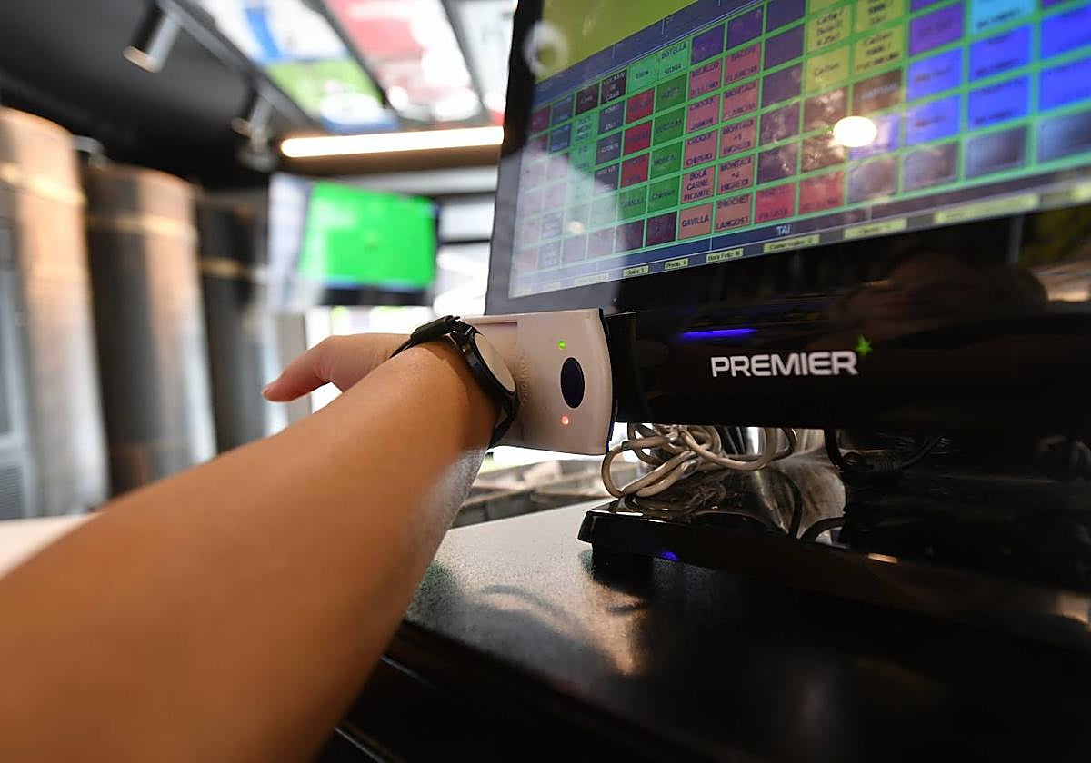 Un camarero ficha con su pulsera.