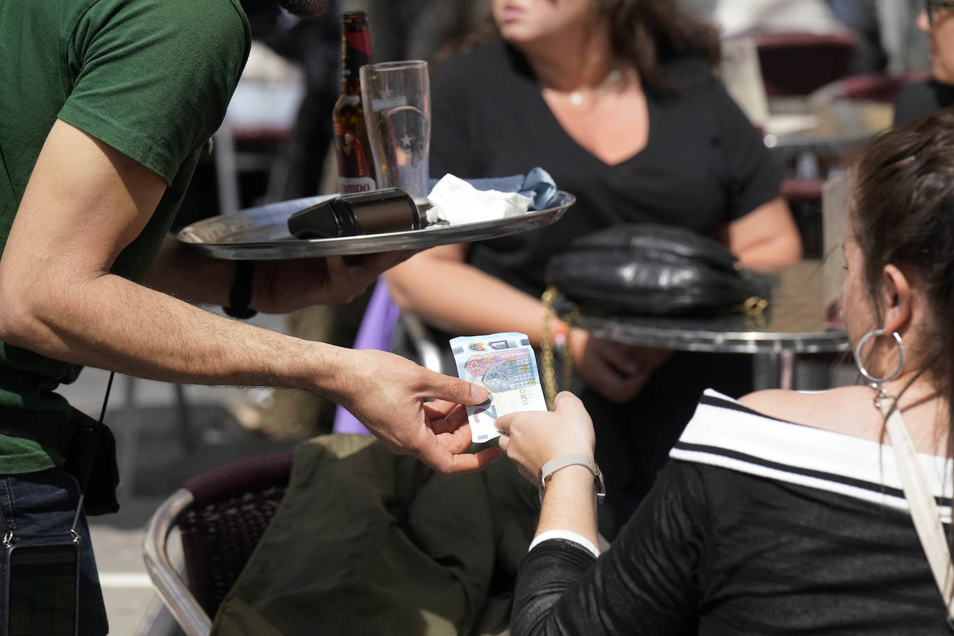 Un cliente abona una consumición en una terraza de Donostia.