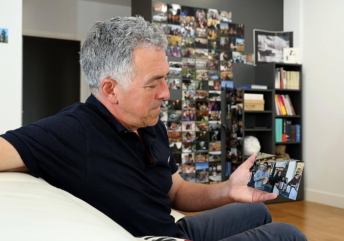 Mikel Manzano observa una fotografía en la que aparece su hijo tocando un pandero. Al fondo, más imágenes de él.
