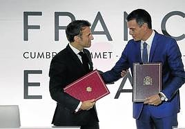 Emmanuel Macron y Pedro Sánchez se saludan e intercambian documentos tras la cumbre hispanofrancesa de Barcelona el pasado 19 de enero.