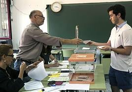 Un joven deposita su voto en la urna en un colegio electoral.