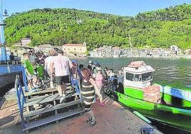 Varias personas desembarcan en Pasai San Pedro de la motora que les ha traído de Pasai Donibane.