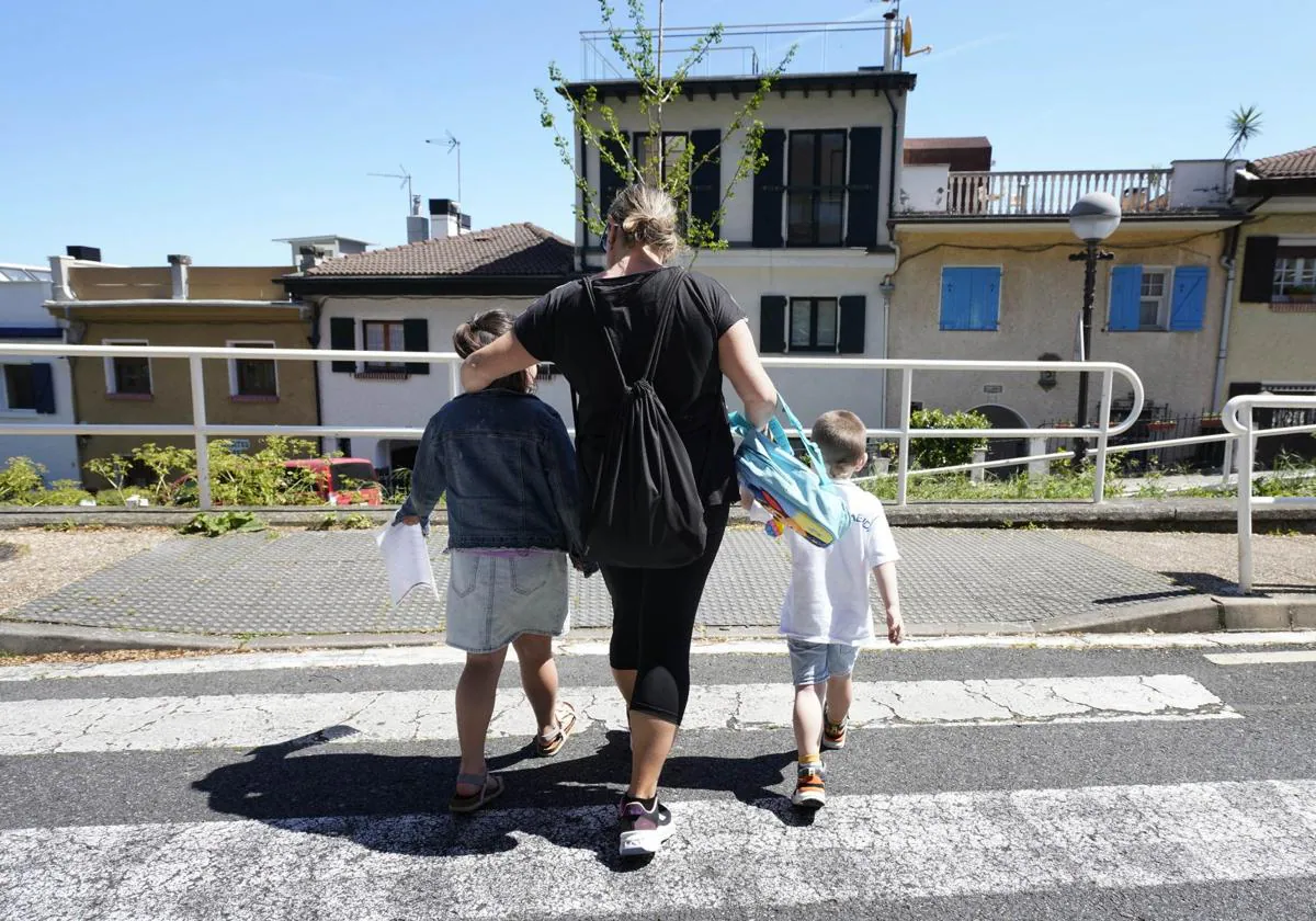 Una madre recoge a sus hijos ayer en el colegio Larramendi de Donostia.