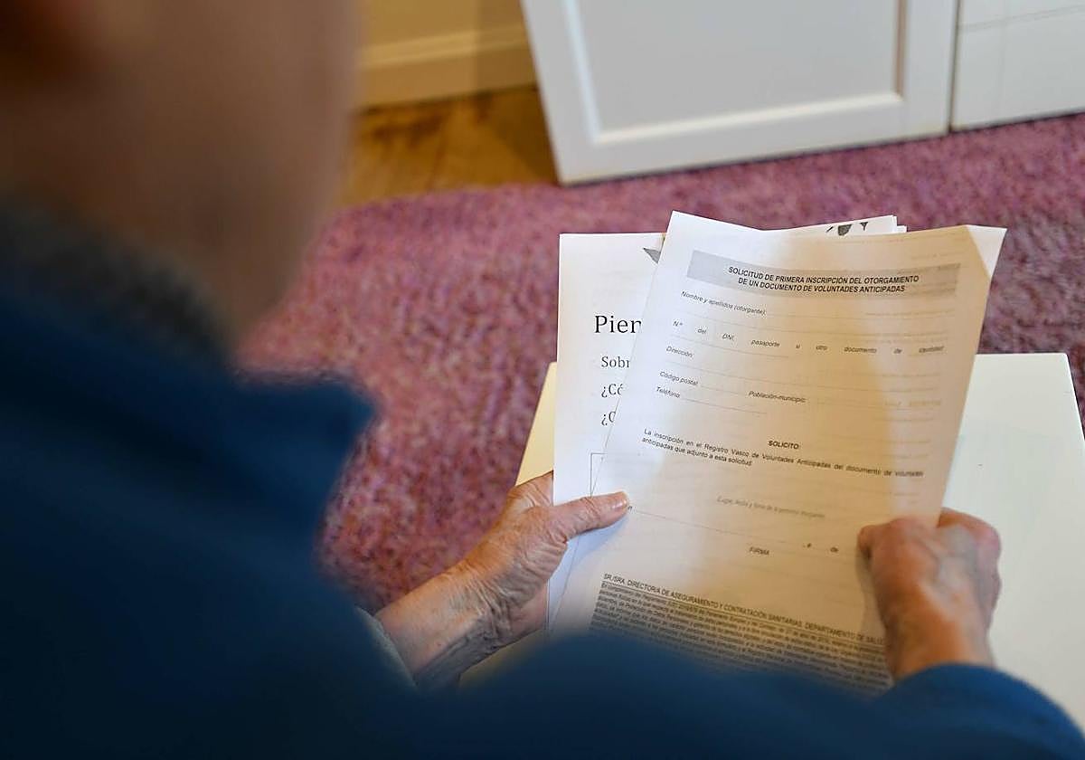 Una persona sostiene entre sus manos una solicitud de inscripción del documento de voluntades anticipadas.