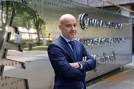 Mauri Arregui, presidente de la Cámara de Comercio de Gipuzkoa, posa ante el gran logo situado junto a la entrada de la institución.