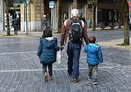Un abuelo pasea con sus nietos.
